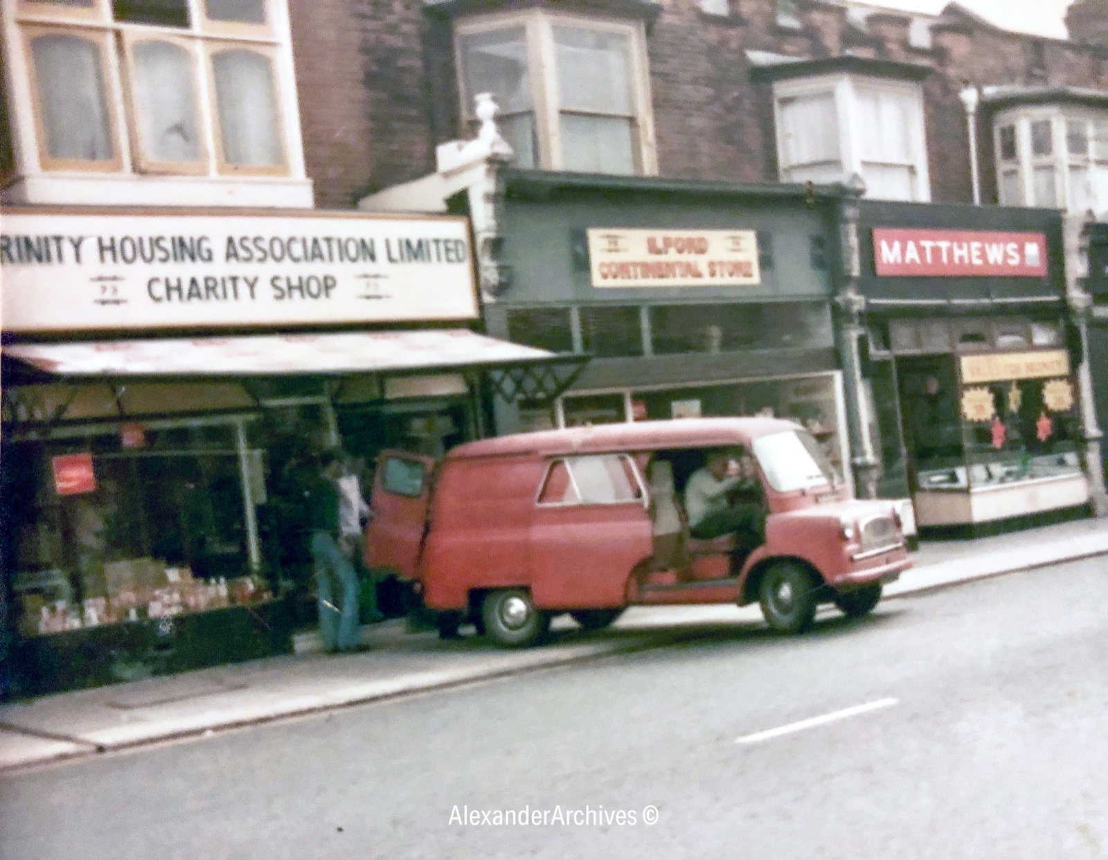 Trinity Housing Association charity shop in London, circa 1970, with a red van parked outside