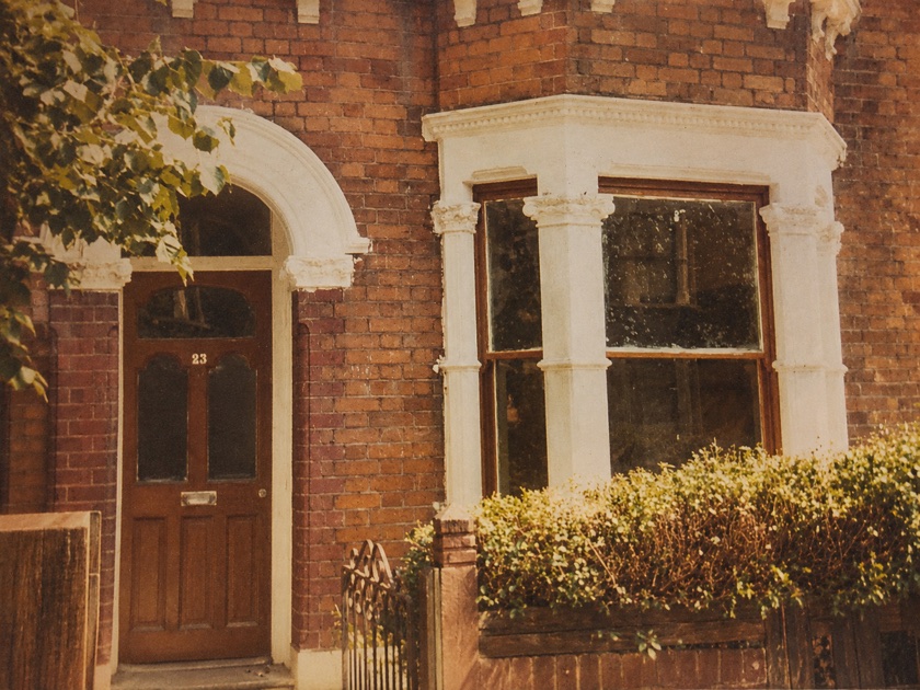 Archive colour photograph of the front door and bay window of a brick house