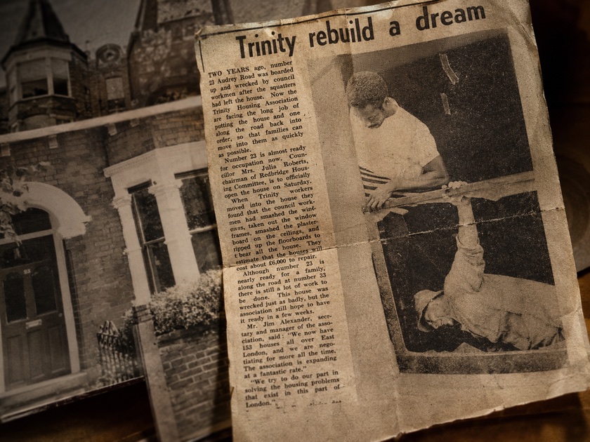 Newspaper clipping headlined Trinity rebuild a dream shown with an archival photograph of a brick house